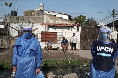 Dos trabajadores sanitarios, a principios de agosto con vecinos de Villa Fiorito (Buenos Aires, Argentina).