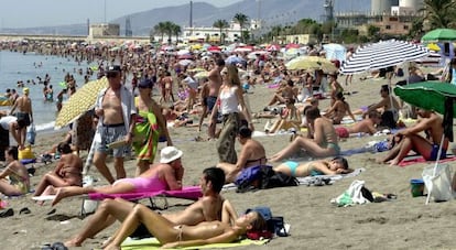 Turistas nacionales y extranjeros en la playa de M&aacute;laga.