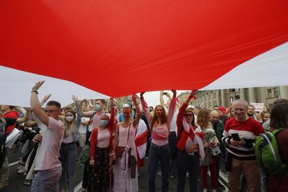 La mayoría de los ciudadanos que participan en las protestas de hoy están ataviados con banderas rojiblancas, símbolo de la oposición bielorrusa. En la imagen, algunos manifestantes con una bandera histórica de Bielorrusia.