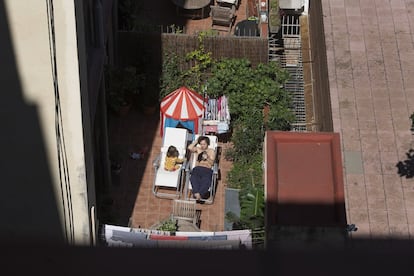 Jan toma el sol con una de sus hijas en el patio de su casa en el barrio de l'Eixample de Barcelona.