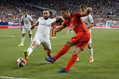 El jugador del Real Madrid, Dani Carvajal, intenta parar un pase de Ben Arfa del París Saint-Germain en el interior del área del equipo madrileño.