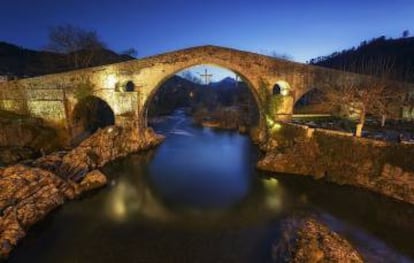 Del puente de Cangas de Onís cuelga una réplica de la cruz de la Victoria.