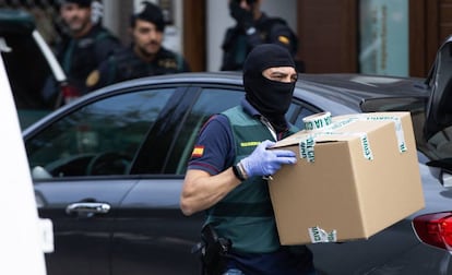 A Civil Guard officer takes material from one of the homes raided on Monday.