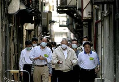 El jefe del Gobierno local de Hong Kong, Tung Chee-hwa ( en el centro), ayer en una de las calles de la ciudad.