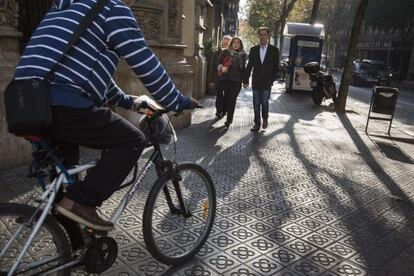 Un ciclista atraviesa esta mañana una acera de Barcelona.