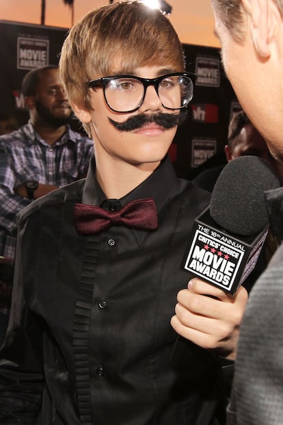No está jugando al Quién es quién, es Justin disfrazado de reportero. 