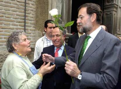 Rajoy (derecha) y el alcalde de Granada, José Torres Hurtado, conversan con una florista en la capital andaluza.