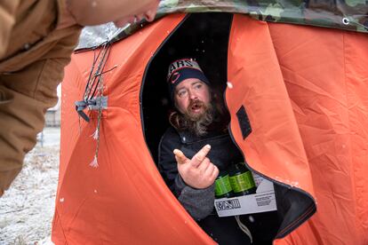 A volunteer from the "Orange Tents" project delivers propane tanks to Peter Zielinski, one of the shelter users, to be used in a portable heater on December 22, 2022.