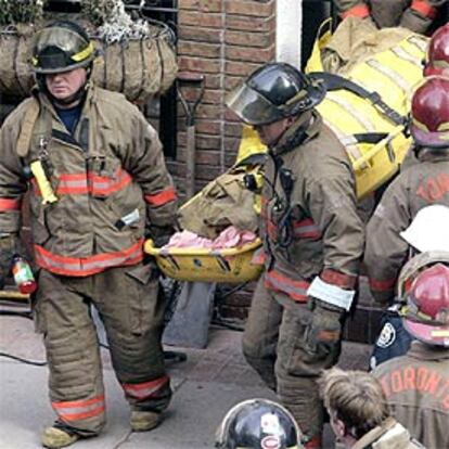 Los bomberos retiran un cuerpo de entre los escombros.