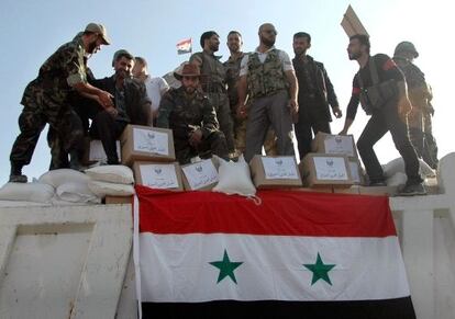 Soldados leales al Gobierno sirio en un camión con víveres en Qusair.