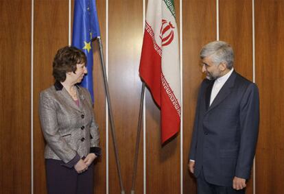 Catherine Ashton y Saeed Jalili posan con sus respectivas banderas al inicio de la cita.