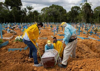 Varios operarios entierran a una víctima fallecida por coronavirus, en un cementerio improvisado en Manaos (Brasil). El país, uno de los más afectados por la pandemia en el mundo, con cerca de 198.000 muertes y 7,8 millones de casos, aún no tiene una fecha para el inicio de su vacunación contra la covid-19 por el atraso de los laboratorios en registrar sus antídotos y por sus propios errores y divergencias.