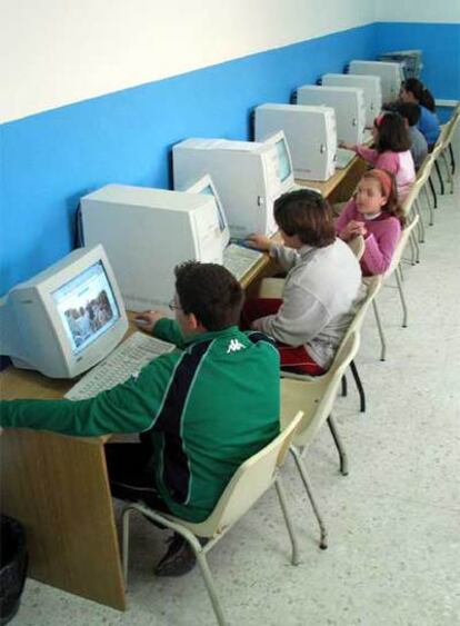 Un grupo de niños estudiando con ordenadores.