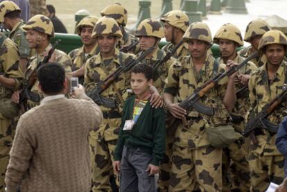 Un egipcio toma una foto de su hijo con soldados del Ejército en la plaza cairota de Tahrir.