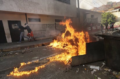 Una carretera cortada por el fuego de una barricada.