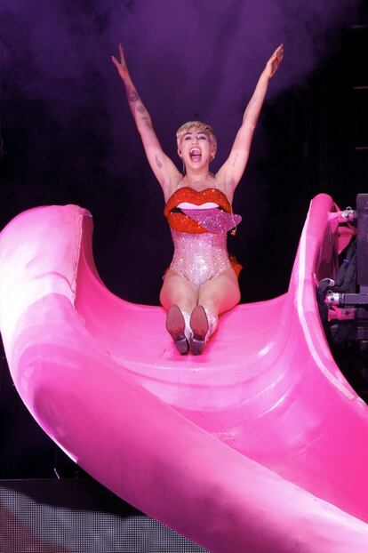 Miley Cirus aparece en el escenario tirándose desde un tobogan.