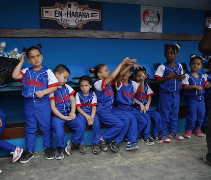 Un grupo de niños esperan en el banquillo para acompañar a los jugadores.