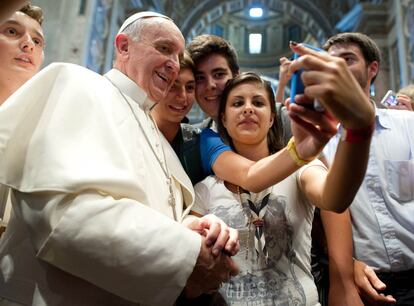 29 de agosto de 2013, unos jóvenes se fotografian con el papa Francisco en el interior de la Basílica de San Pedro, en el Vaticano.