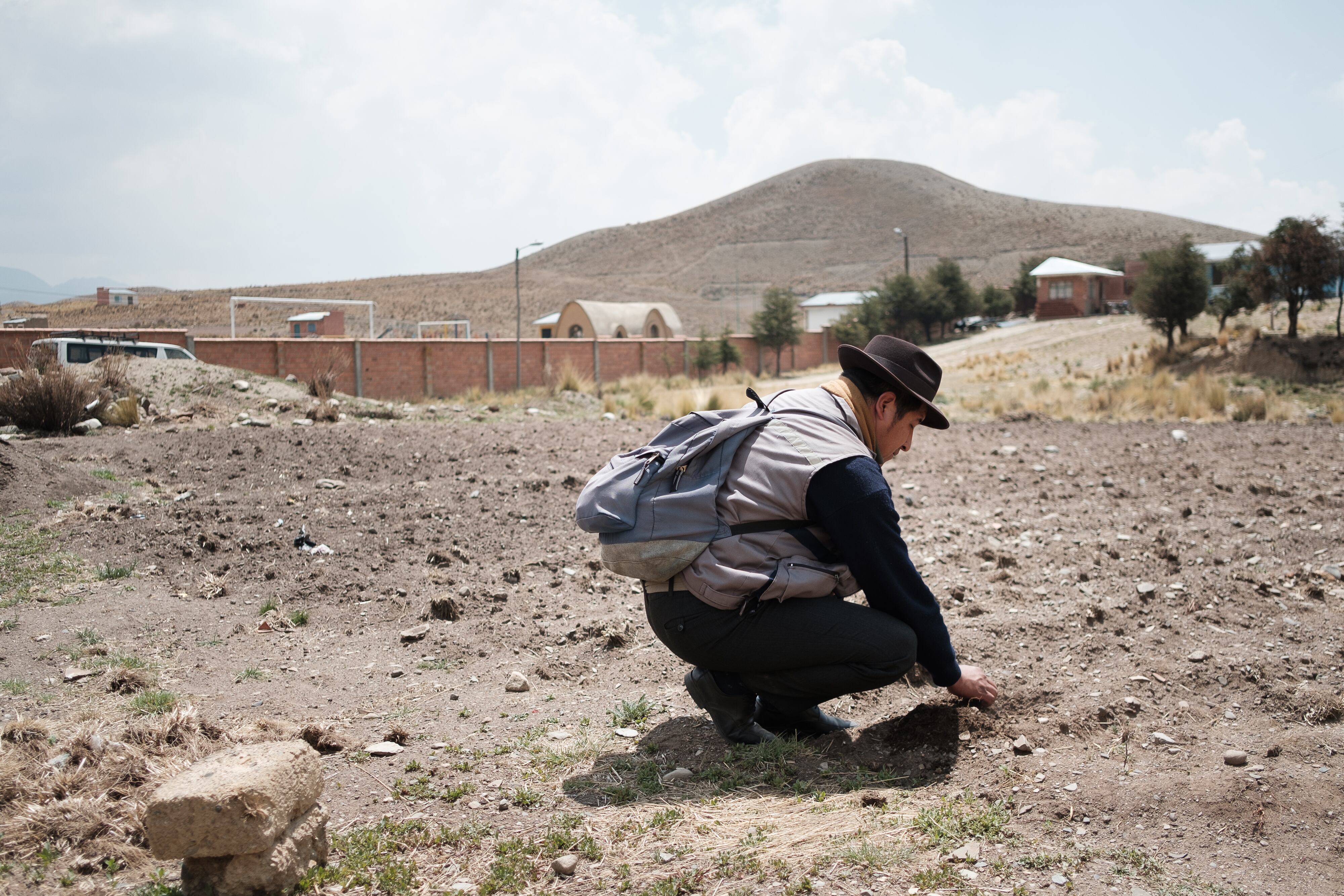 El ‘jilakata’ David Poma, jefe de la comunidad de Siete Lagunas, revisa la humedad del suelo de la zona de cultivo de la escuela.