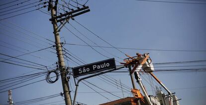 Un t&eacute;cnico de Eletropaulo, trabajando en un poste el&eacute;ctrico en el centro de Sao Paulo (Brasil).