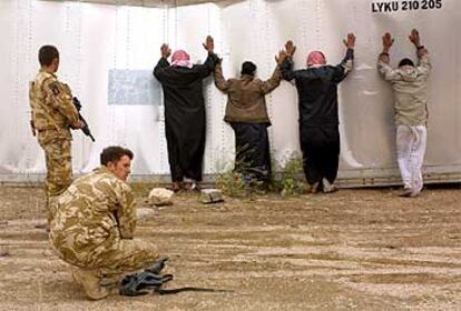 Unos soldados británicos vigilan a unos presuntos saqueadores en una refinería cercana a Basora.