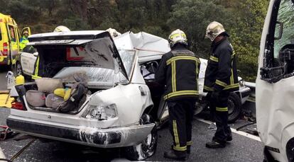 Los bomberos inspeccionan el vehículo Mercedes siniestrado en Navas del Rey.