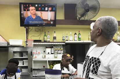 Un hombre sigue la entrevista con Jair Bolsonaro en televisión en un bar de São Paulo
