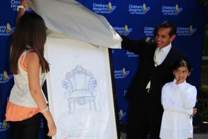 El alcalde Antonio Villaraigosa (centro) desvela una de las 13 pinturas de Michael Jackson ante los hijos del rey del pop Paris (izquierda) y Blanket (derecha).