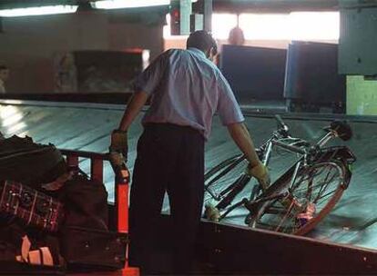 Un operario recoge equipaje en el aeropuerto de Barajas.