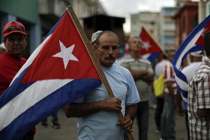 Un hombre lleva una bandera cubana a la ceremonia que tuvo lugar en Plaza de la Revolución. 
