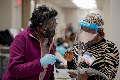 Las inspectoras electorales Beatrice Antwi (derecha) y D. Jones, revisan un manual en un centro de votación durante la jornada electoral, en el distrito del Bronx en Nueva York.