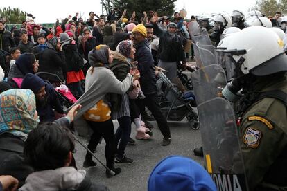 Refugiados y migrantes se enfrentan a la policía antidisturbios durante una manifestación frente al campamento de Kara Tepe, en la isla de Lesbos (Grecia).