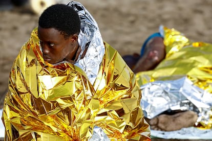 Dos migrantes tras ser atendidos por los servicios sanitarios tras su llegada en patera a la playa de Las Burras, en Gran Canaria. 