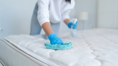 Una mujer limpiando un colchón con sanytol.