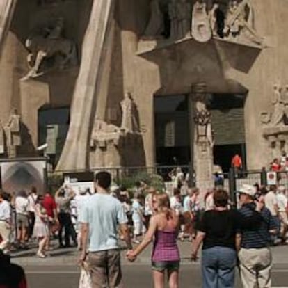 Decenas de turistas hacen cola para entrar en la Sagrada Familia, en Barcelona.