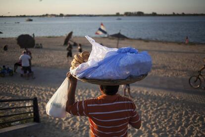 Un hombre vende chipa, panecillo de harina de maíz, mandioca y queso, en la cCostanera de Asunción, una ciudad donde la venta ambulante de comida es una tradición. La mayoría de las personas en Paraguay tiene un trabajo informal.