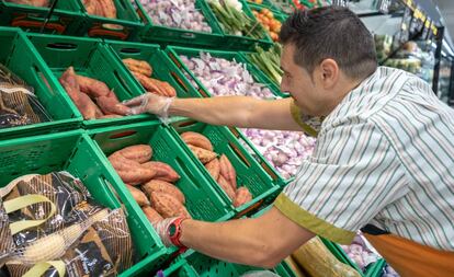 Un empleado, en la sección de fruta de un supermercado Mercadona.