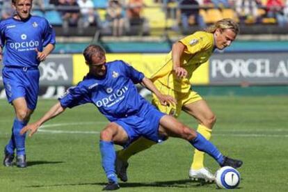 Pernía se lleva el balón ante Forlán, delantero del Villarreal.