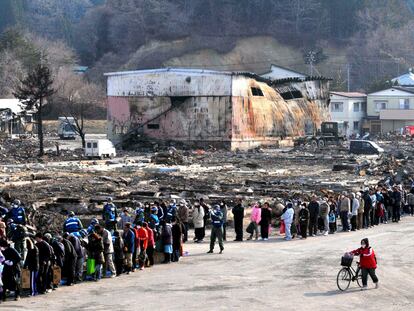 Cientos de damnificados por el tsunami hacen cola para recibir comida y papel higiénico en un reparto organizado por el Ejército en Yamada (prefectura de Iwate).