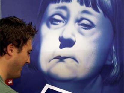 Un visitante mira un libro de caricaturas de la futura canciller alemana, Angela Merkel, ayer en la Feria de Francfort.