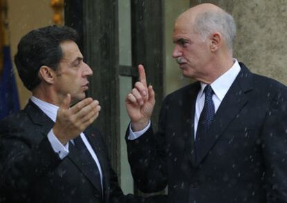 El presidente de Francia, Nicolas Sarkozy, junto al primer ministro griego, George Papandreu, bajo la lluvia en París.