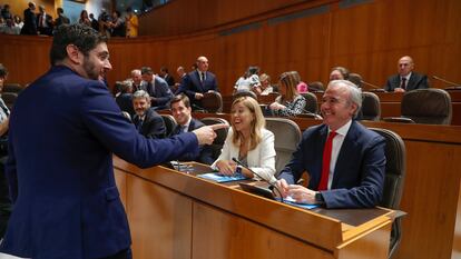 El diputado de Vox Alejandro Nolaso saluda al diputado del PP, Jorge Azcón, al inicio del pleno de constitución de las Cortes de Aragón, este viernes. 