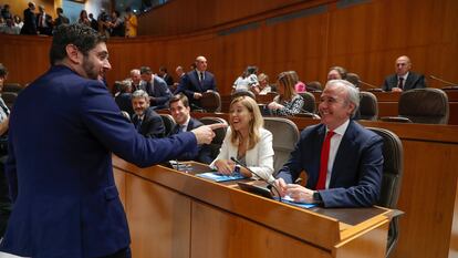 El diputado de Vox Alejandro Nolaso saluda al diputado del PP, Jorge Azcón, al inicio del pleno de constitución de las Cortes de Aragón, este viernes.