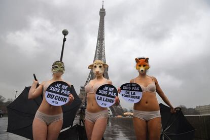 Tres mujeres con máscaras de animales y pancartas que leen "Yo no soy de cuero", "No soy de lana" y "No soy peluda" durante una acción coordinada por la organización de derechos de los animales, PETA, para protestar contra el uso de pieles de animales durante la Semana de la Moda, frente a la Torre Eiffel de París (Francia).