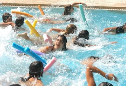 Uns nens juguen en una piscina municipal.