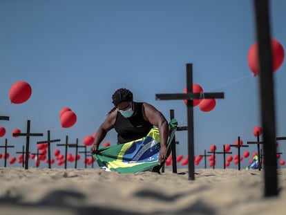 Una activista instala una bandera de Brasil en una tributo para las víctimas de la covid-19 en Río de Janeiro, este sábado.