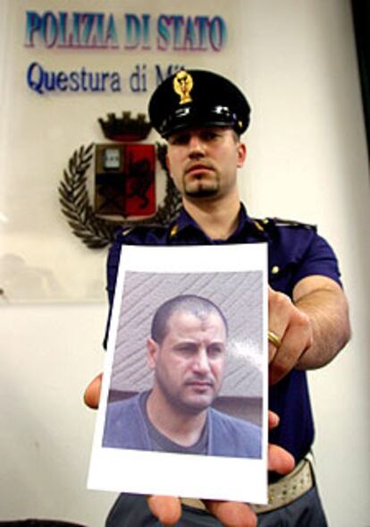 Un policía italiano exhibe la fotografía de Rabei Osman, detenido en Milán en junio.