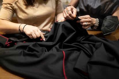 Two of the seamstresses at the Mancinelli tailor shop work on a black talar habit for a cardinal.