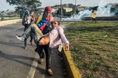 Manifestante ferido é levado durante protesto em Caracas, em maio de 2017.