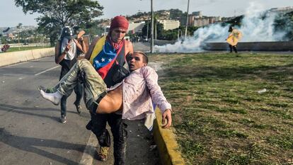 Manifestante ferido é levado durante protesto em Caracas, em maio de 2017.